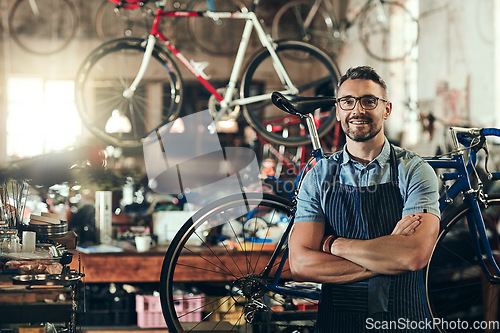 Image of Portrait, smile and repair man in bicycle shop with arms crossed working in store. Face, bike mechanic and confident male person from Canada with happiness, glasses and mature in cycling workshop.