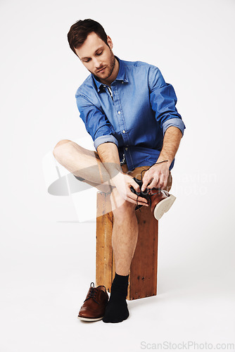 Image of Fashion, shoes and man in studio against white background for getting ready or dressing. Socks, choice and casual male with outfit for style, decision and fashionable or trendy clothing aesthetic