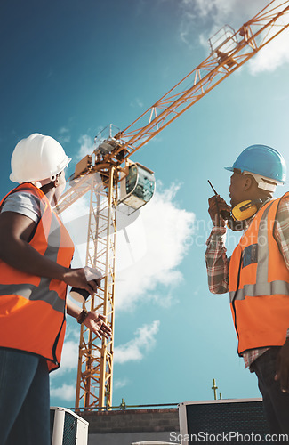 Image of Construction, engineering and team with walkie talkie and crane for building project, teamwork or architecture. Black woman and man manager together for engineer planning or safety inspection outdoor