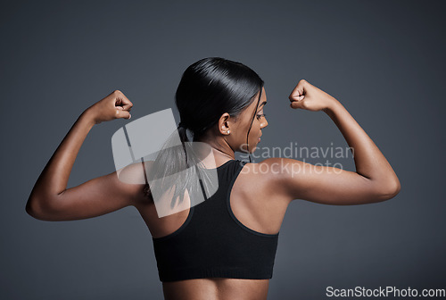 Image of Sports, workout and woman flexing back in studio isolated on a black background. Strong flex, muscle and female athlete with bicep, arm strength or bodybuilder training, fitness and healthy exercise.