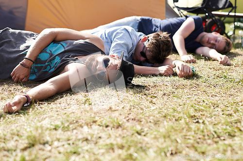 Image of Drunk sleeping, hangover and party people on camping park at music festival with alcohol. Field, ground and lawn with a tent and youth on grass with male friends and man camper at concert outdoor