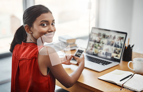 Image of Business woman, portrait and smile with a phone and laptop at desk for media, research and creative work or blog. Happy Indian female entrepreneur with a smartphone and internet for communication