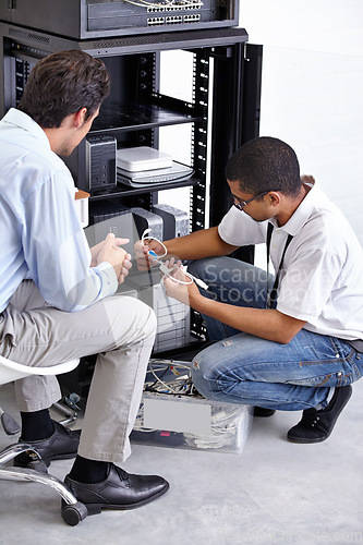 Image of Server room, man or electrician with working electronics for hardware maintenance or fixing glitch in office. IT support or worker with a technician or electrical engineer for information technology