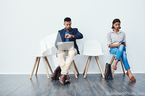 Image of Phone, laptop and people in waiting room for an internship search the internet, web or website sitting on chairs. Interview, work and young employees texting and typing online ready for a new job