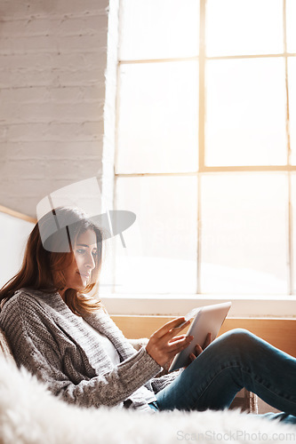 Image of Window, tablet and credit card with a woman online shopping on a sofa in the living room of her home. Ecommerce, finance and fintech banking with a young female user, customer or shopper in a house