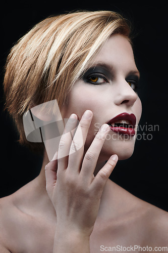 Image of Portrait, hand and a woman vampire in studio on a dark background as a cosplay monster. Fantasy, horror or scary with an attractive young halloween female person posing as an evil and supernatural