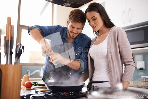 Image of Happy couple, pan and cooking together in the kitchen with food or healthy ingredients for dinner at home. Man and woman smiling in happiness for meal preparation, lunch or frying vegetables on stove