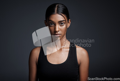 Image of Portrait, serious and Indian woman with fitness, exercise and confident girl against a dark studio background. Face, female person and athlete with determination, endurance and workout for wellness