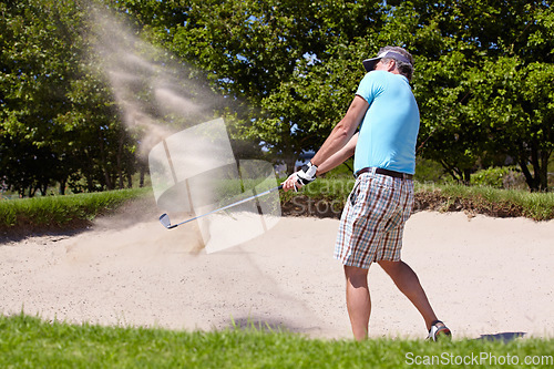 Image of Golf, sport and a man on course for training, professional game or a hobby in retirement. Sand, summer and an elderly player hitting a ball with a club for sports, golfing and recreation as a senior