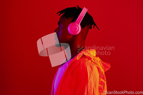 Image of Headphones, neon fashion and black man profile with music and online song streaming. Internet radio, web audio and African male model with red background in a studio with gen z style and clothing