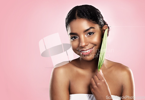 Image of Portrait, happy woman and leaf for skincare in studio, pink background and mockup of vegan dermatology. Face, african model and leaves for eco friendly beauty, natural glow or cosmetic sustainability