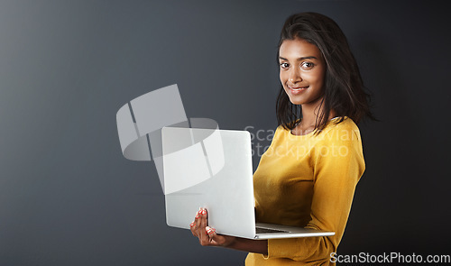 Image of Laptop, portrait and woman blogging or working online, internet or web isolated on a gray studio background. Mockup, social media and happy female person or student writing and using technology