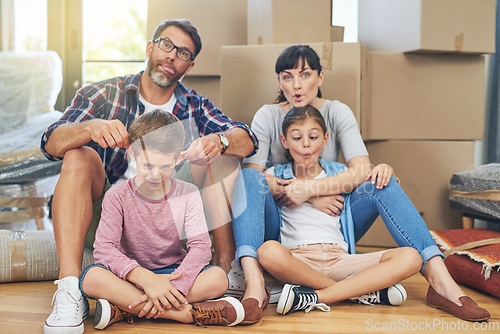 Image of Family, portrait and funny face in apartment with boxes as an investment for mortgage in real estate. Kids, parents and box with comic mood in new house with happiness are silly on the floor.