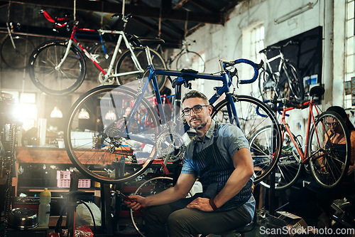 Image of Portrait, wrench and mechanic man in bicycle shop, store or cycling repair workshop. Face, bike technician and male person, serious business owner or mature professional with glasses and confidence.