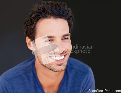 Image of Face, smile and handsome man or happy male with white teeth or oral hygiene and isolated on a dark, black background. Motivated, cheerful and attractive guy or dental health or beauty in studio