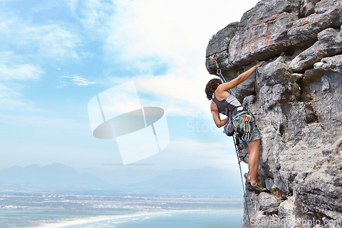 Image of Rock climbing, travel and blue sky with woman on mountain for adventure, cliff and space. Strong, freedom and mockup with female climber training in nature for courage, safety and workout challenge
