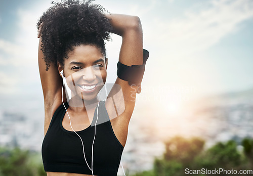 Image of Fitness, portrait and happy woman stretching outdoors with music for running, workout or cardio. Face, smile and African female runner in nature with podcast for training, motivation or sport routine