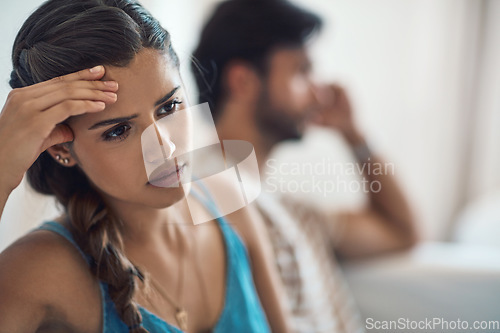 Image of Unhappy, upset or sad with a couple arguing on a sofa in their home living room about an affair or breakup. Depression, abuse or domestic violence with a woman thinking about divorce after a fight