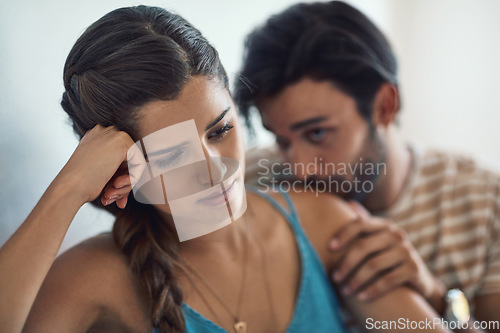 Image of Unhappy, upset or sadness with a couple fighting on a sofa in their home living room about an affair or breakup. Depression, abuse or conflict with a sad woman thinking of divorce while arguing