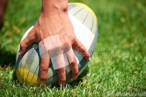 Image of Rugby player, ball sports and hand of a man while outdoor on a pitch wit green grass or lawn. Male athlete person playing in sport competition, game or training match for fitness, workout or exercise