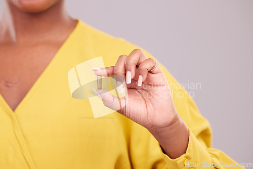 Image of Pharmaceutical, hand and woman with a pill in a studio for healthcare, wellness or recovery medication. Medical, medicine and closeup of female person with tablet capsule isolated by gray background.