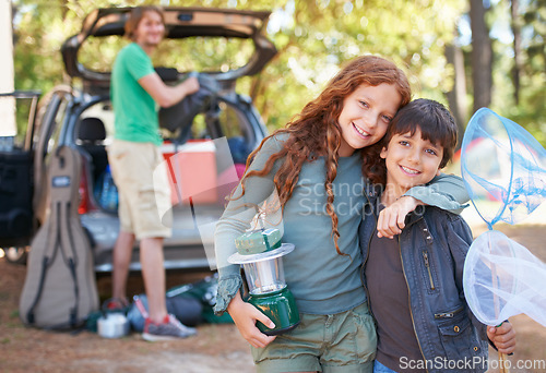 Image of Happy siblings, portrait and hug for camping holiday, road trip or family vacation together in nature. Sister hugging brother with smile and lantern for camp adventure, travel or getaway in forest
