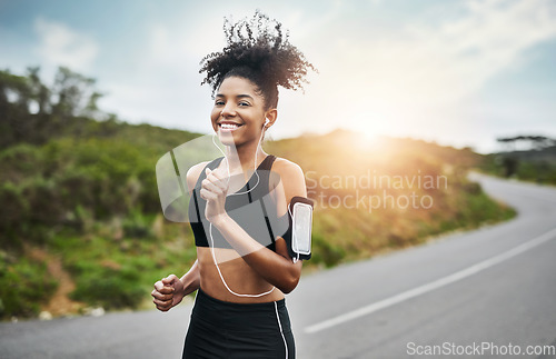 Image of Sports, portrait and happy woman running in road with music earphones, workout or cardio routine. Smile, exercise and face of female runner in nature with podcast for training, energy and fitness