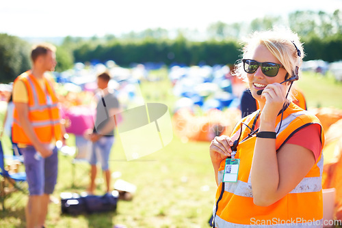 Image of Festival security, communication and a woman outdoor on a grass field for safety at a music concert. Party, event and crowd control with a female officer using a headset microphone for protection