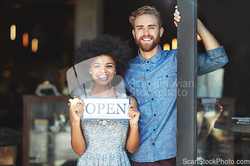 Image of Coffee shop, open and couple portrait as small business owner or team in partnership with pride. Smile of a man and woman with signage, diversity and welcome sign as waiter and barista of restaurant