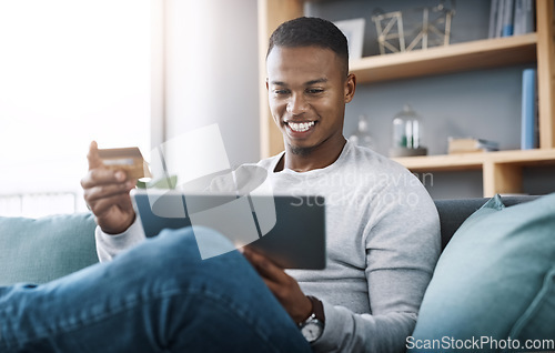 Image of Online shopping, tablet and happy man with credit card on couch surfing website for discount sale or promotion. Happiness, internet payment and smile, man on digital ecommerce subscription service.