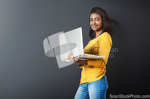 Image of Laptop, portrait and woman typing online, internet or web email isolated in a studio grey background feeling happy. Mockup, social media and female student or person working and using technology