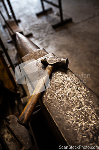 Image of Hammer, anvil and blacksmith workplace in a iron factory and industrial workshop. Tools, metal work and steel artisan bench with craftmanship equipment to forge in warehouse with metals and materials