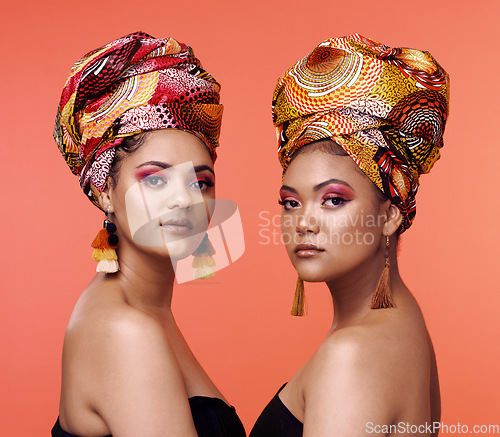 Image of African fashion, beauty and portrait of women on orange background with cosmetics, makeup and accessories. Glamour, studio and face of female people with exotic jewelry, traditional style and luxury