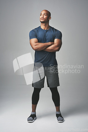 Image of Arms crossed, fitness and man thinking isolated on studio background for healthy body and workout ideas. Confident, vision and strong athlete, bodybuilder or African person, exercise and sports power