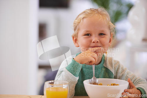 Image of Portrait, morning and a child eating breakfast with happiness, hungry and smile at a home table. Happy, young and a little girl smiling for food, cereal and enjoying a meal for nutrition in a house