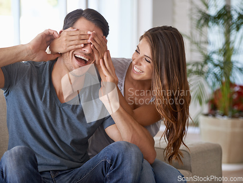 Image of Couple, surprise and hands cover eyes for happy reveal in home living room or woman, sitting together with partner and sofa. Girlfriend, man and love or playing, guess who or excited announcement