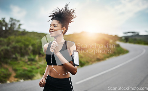 Image of Fitness, sports and happy woman running in a road with music for health, workout or cardio routine. Smile, exercise and African female runner in nature with podcast for training, motivation or energy