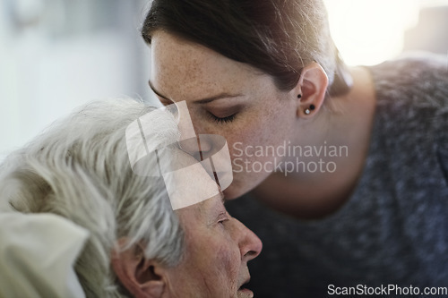 Image of Senior, daughter and kiss mother in hospital for healthcare, visiting sick patient and resting. Clinic, woman and kissing elderly mom on forehead with love, care and empathy, kindness and comforting.