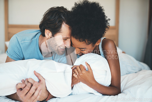 Image of Happy interracial couple, bed and laughing in relax for intimate morning, bonding or relationship at home. Man and woman smiling with laugh in joyful happiness or relaxing weekend together in bedroom