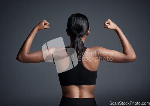Image of Sports, exercise and woman flexing back in studio isolated on a black background. Strong flex, muscle and female athlete with bicep, arm strength or bodybuilder training, fitness and healthy workout.