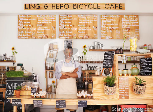 Image of Portrait, black man and barista with arms crossed in cafe with pride for career or job. Waiter, smile and confidence of African person from Nigeria in restaurant, small business and coffee shop.