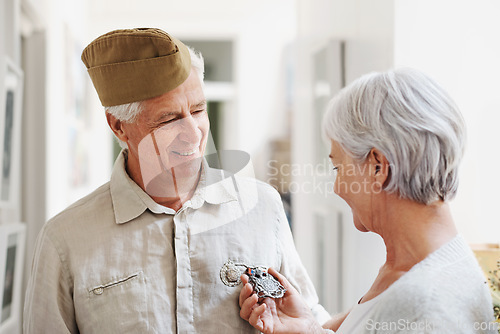 Image of Military, medal and honor with a senior couple in their home, feeling nostalgic about army service. War hero, award or memory and a mature man soldier in a house with his wife, feeling patriotic