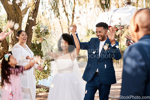 Image of Wedding day, couple celebrate and confetti outdoor with happiness and hands up at marriage event. Celebration, happy people and African bride walking with flower bouquet at love commitment ceremony