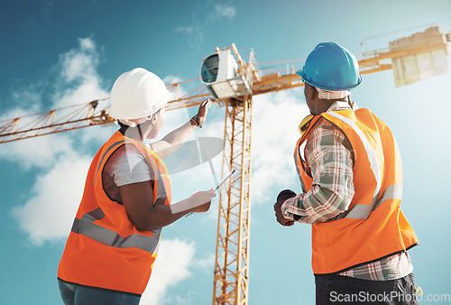 Image of Construction, engineering and team with tablet and crane for building project, teamwork or architecture. Black woman and man manager talking outdoor for engineer planning, vision or safety inspection