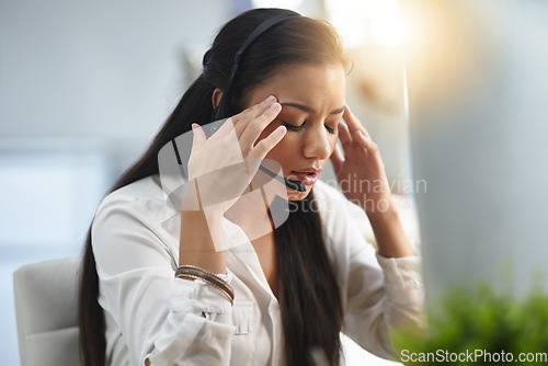 Image of Call center, stress or woman with headache or burnout is overworked by telemarketing deadline. Depressed, sad or tired sales woman frustrated with migraine pain or fatigue in customer services office