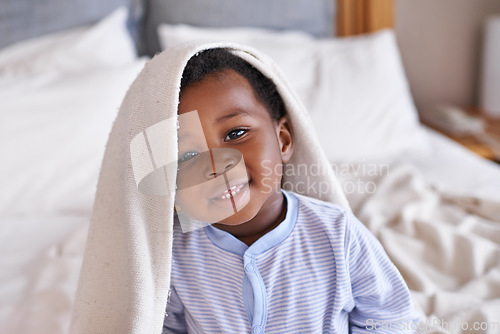 Image of Portrait, happy and baby with a blanket in bed, waking up and playing in his home. Face, smile and african boy toddler in a bedroom curious, having fun and sweet, cute and playful while relaxing