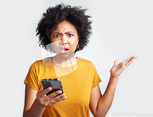 Image of Portrait, young woman and surprised with phone on hand and omg with text or spam on social media and online news. Technology, communication and scam announcement on grey studio background.