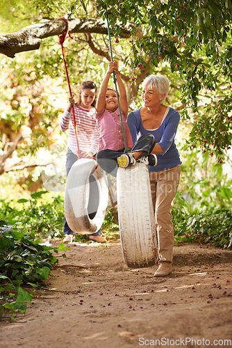 Image of Elderly woman, tire swing and grandma playing with grandkids or holidays and having fun in a garden in summer. Excited, grandchildren and outdoors swinging together or on sunny weekend at a park