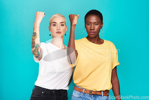 Image of Women, fight and portrait with fist for human rights, lgbt and revolution gesture for power. Diversity and pride of young people with blue background in studio with rally, equality and protest sign