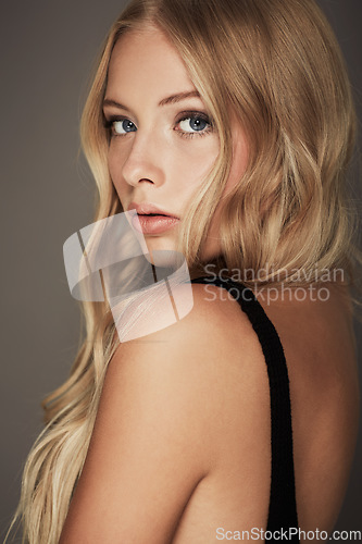 Image of Beauty, face and portrait of a woman with makeup, cosmetics and long hair in studio. Headshot of a female aesthetic model with a skin glow, luxury skincare and seductive fashion on a grey background